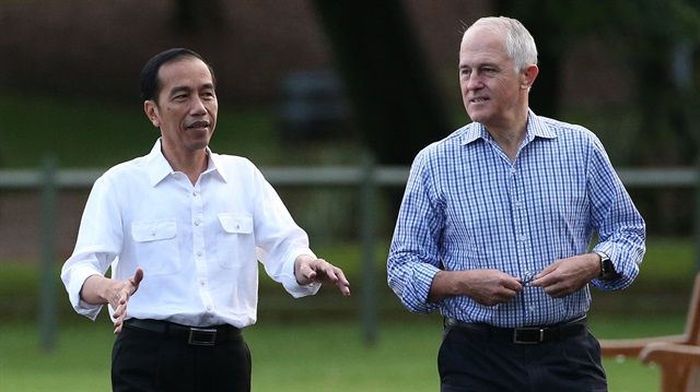 Indonesian President Joko Widodo gestures as he walks with Australian Prime Minister 