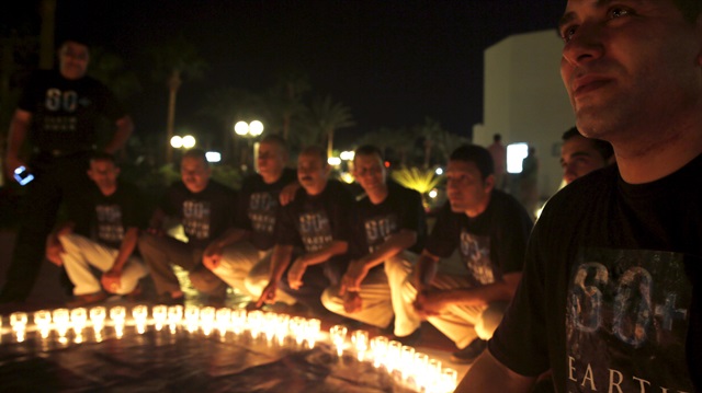 Members of "Peace Time" place candles in the shape of the Earth, during an event for "Earth Hour" in the Red Sea resort of Sharm el-Sheikh 

