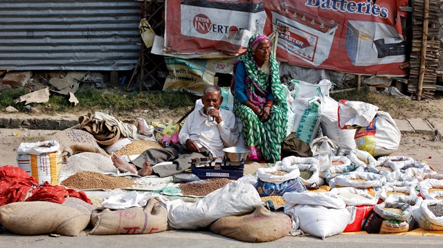 A couple selling food grains waits for customers at a roadside market in Lucknow