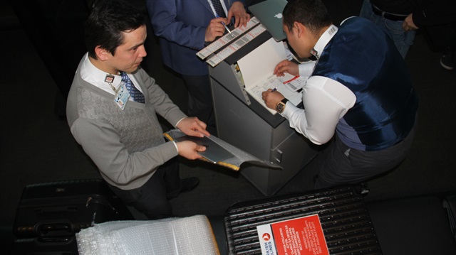 Turkish Airlines personnel take passengers' electronic devices such as tablets and laptops at the boarding gate and store them in special containers