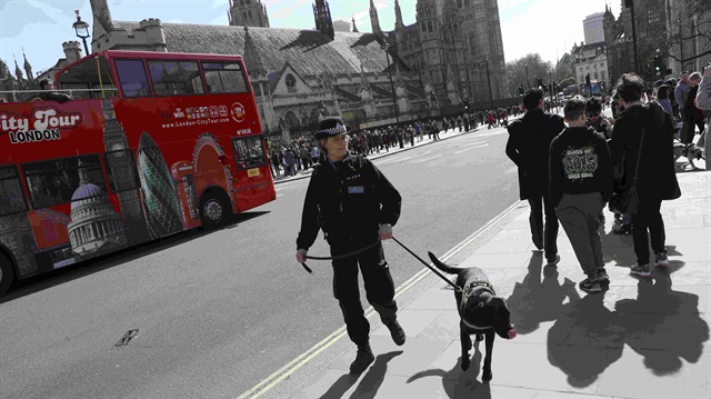 A police dog handler patrols in Parliament Square following the attack in Westminster