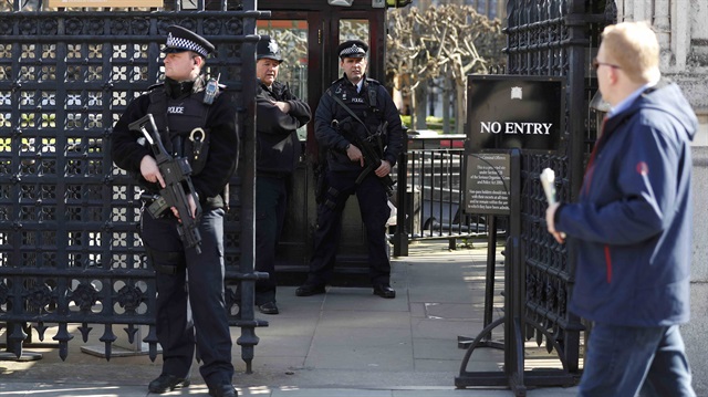 Armed police officers stand at the Carriage Gates entrance to the Houses of Parliament