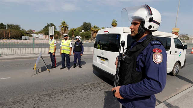 Police and security officials stand guard at a checkpoint on a highway in Sanabis west of Manama, Bahrain
