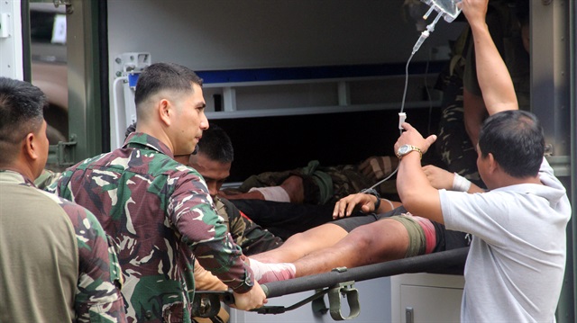 A soldier lays on a stretcher as he is being carried away by his mates to a nearby Camp Bautista hospital after sustaining wounds in a gunfight 


