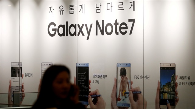 A woman talking on her mobile phone walks past an advertisement promoting Samsung Electronics' Galaxy Note 7 at company's headquarters in Seoul, South Korea

