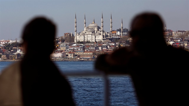People travel in a ferry with the Ottoman-era Sultanahmet mosque