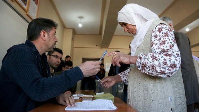 A woman gets her ballot papers at a polling station during a referendum in the southeastern city of Diyarbakir, Turkey, April 16, 2017.
