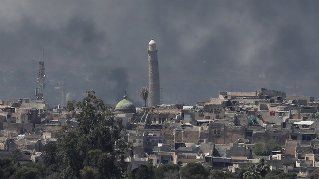 A smoke rises above Al-Nuri mosque in the old city as Iraqi forces fight Daesh