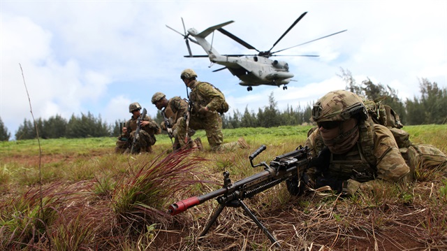 Private Jessie Starks of the Royal Australian Army 2RAR sets up a perimeter defense during a helicopter insertion exercise with US Marines in the Kahuku mountains training area during the multi-national military exercise.
