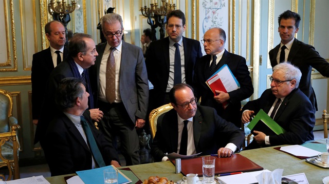 French President Francois Hollande speaks with ministers and officials at the end of a defense council at the Elysee Palace in Paris.