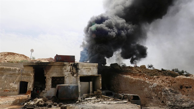 Smoke rises from an emergency service point after an airstrike at the opposition-held village of Maar Zita