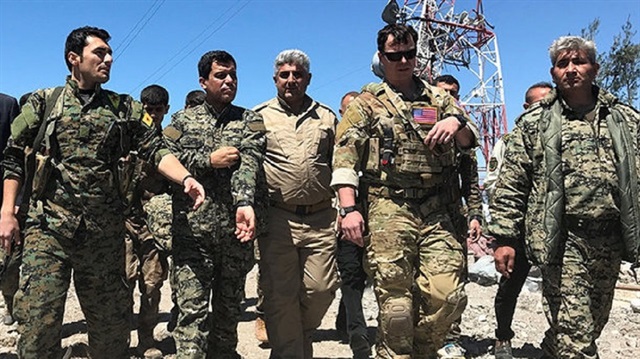 A U.S. commander can be seen walking alongside PKK and YPG terrorists. 