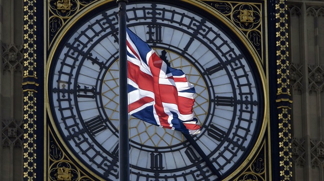 A Union Flag flies in front of the Big Ben clock face abover the Houses of Parliament in central London.