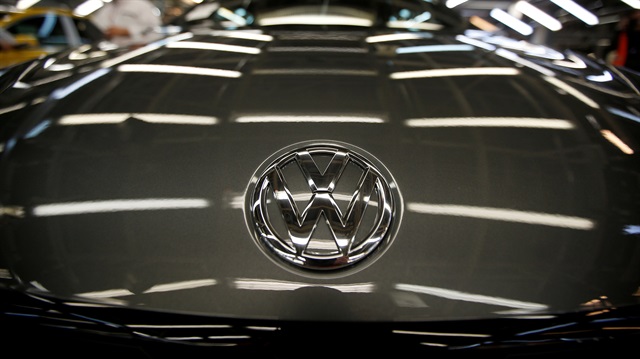 The logo of Volkswagen company is seen on a car on an assembly line 