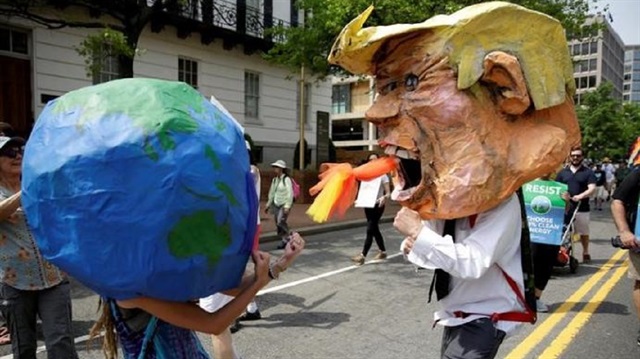 Protesters dressed as the earth and U.S. President Donald Trump pretend to fight during the Peoples Climate March near the White House in Washington, U.S., April 29, 2017.