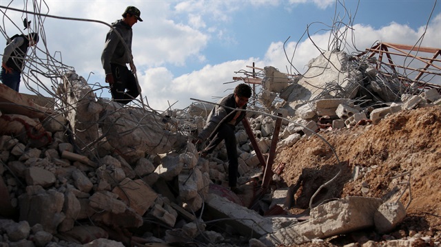 Youth inspect rubble of a damaged house after an airstrike 