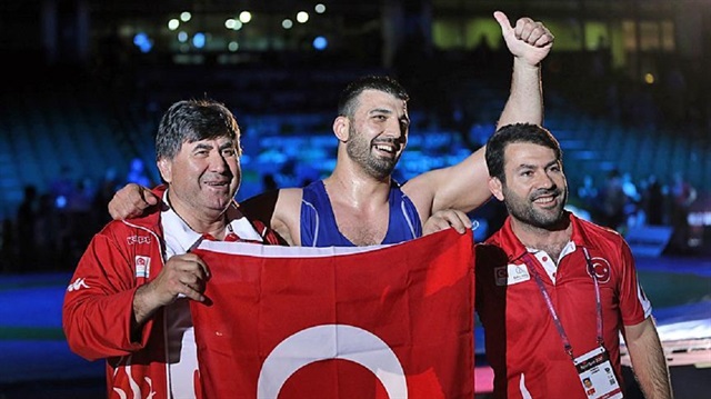 Riza Yildirim (C) of Turkey poses for a photo holding Turkish flag after winning a gold medal during his free style wrestling final match in 97kg against Anzor Boltukaev (not seen) of Russia within European Wrestling Championship 2017 in Novi Sad, Serbia on May 3, 2017.