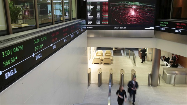 People walk through the lobby of the London Stock Exchange in London, Britain November 30, 2015.