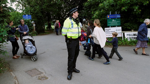 A policeman stands on duty outside a polling station in Sonning, Britain 