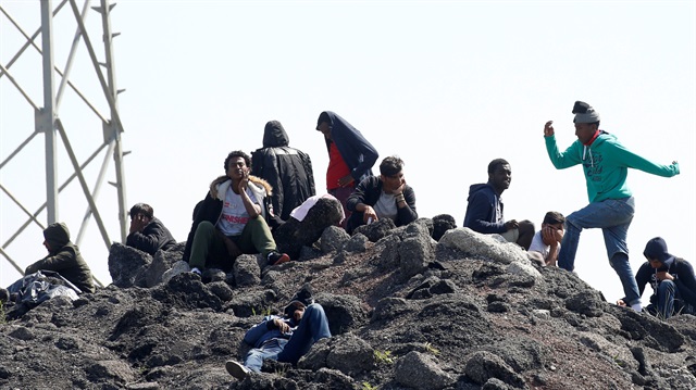 Migrants gather on a heap of loose earth near the former "jungle" in Calais, France, June 1, 2017.