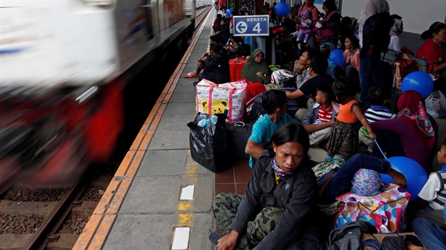 Passengers wait on a platform of Pasar Senen Station for trains taking many of them home for the upcoming Eid al-Fitr holiday marking the end of the Muslim holy month of Ramadan, in Jakarta