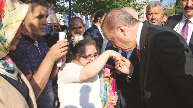 Erdoğan, oyuncak verdiği bir çocuğun elini öperek sevgisini gösterdi.