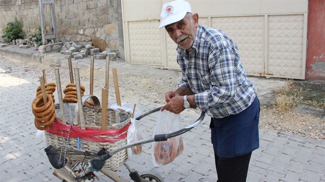 Şükrü Çelik, eski bir bebek arabasına yerleştirdiği sepetiyle sokak sokak gezerek simit satıyor. 