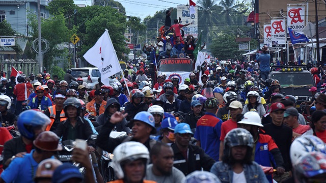 Workers and contractors from PT Freeport travel in a convoy during a rally 