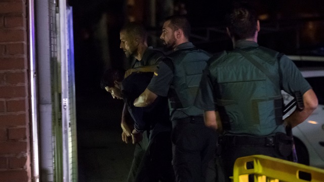 Spanish Civil Guards escort one of four men accused of involvement in a cell behind a van attack in Barcelona last week, in Tres Cantos, Spain.