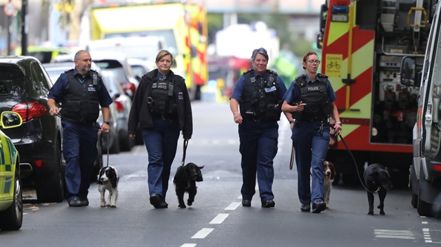 Police officers walk with dogs after an incident at Parsons Green underground station