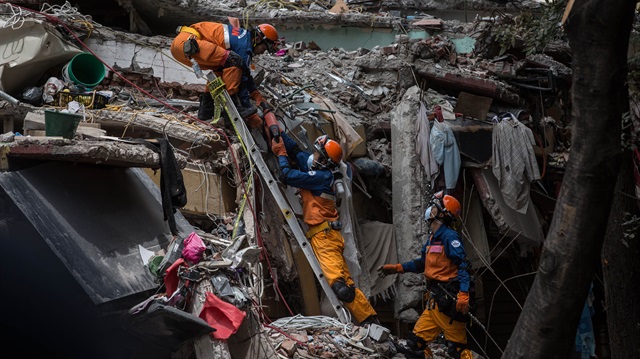 Japanese rescue workers search with a sniffer dog for survivors in the collapsed building at Ciudad Jardin neighborhood during a search and rescue operation following a powerful magnitude 7.1 earthquake that hit Mexico City, Mexico on September 22, 2017.