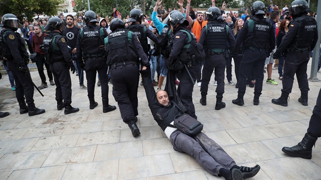 A man is dragged away by Spanish Civil Guard officers, outside a polling station, for the banned independence referendum, where Catalan President Carles Puigdemont was supposed to vote in Sant Julia de Ramis, Spain October 1, 2017.