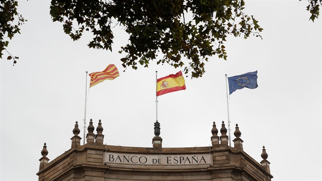 A Catalonian, Spanish and European flag fly on the roof of the Bank of Spain