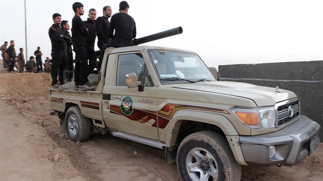 Peshmerga fighters ride in a vehicule in the Southwest of Kirkuk