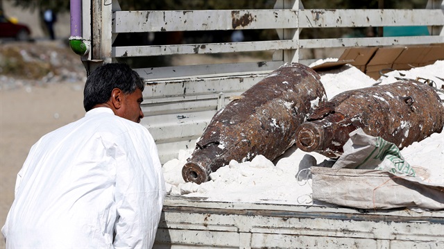 An official inspects unexploded bombs and explosive devices which were seized