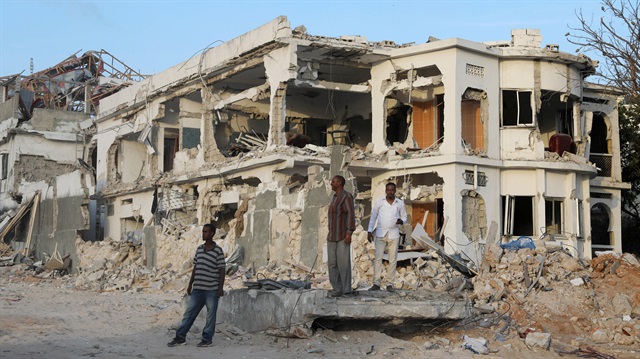 Somali businessmen stand near the scene of last Saturday explosion in KM4 street in the Hodan district in Mogadishu, Somalia.
