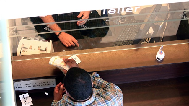 A customer receives money form teller inside the Bank of Khartoum