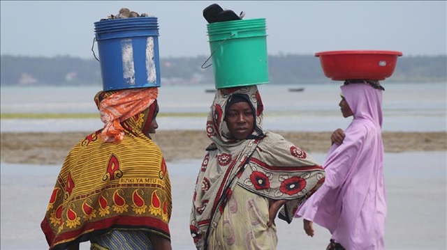 Tanzanian women carry buckets on their heads in Zanzibar