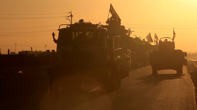 Iraqi security forces members advance in military vehicles in Kirkuk, Iraq.