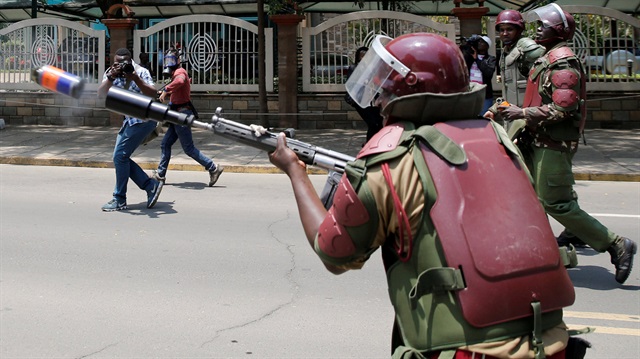 A riot policeman fires tear gas to disperse supporters of Kenyan opposition National Super Alliance (NASA) coalition, during a protest along a street in Nairobi, Kenya.