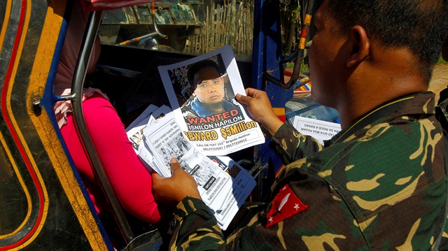 Soldiers distribute pictures of a Abu Sayyaf terrorist Isnilon Hapilon