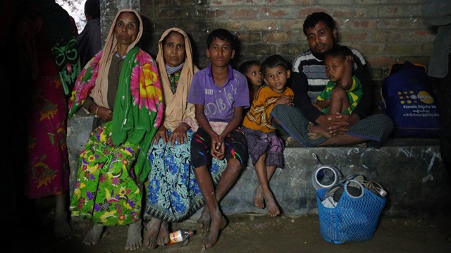 Rohingya refugees wait to receive permission from the Bangladeshi army to continue their way