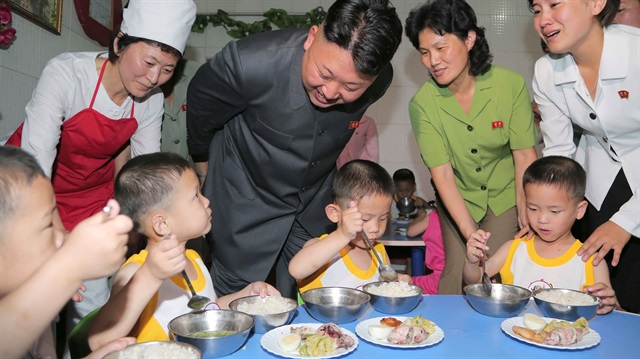 Kuzey Kore lideri Kim Jong-un çocuklarla konuşuyor. 