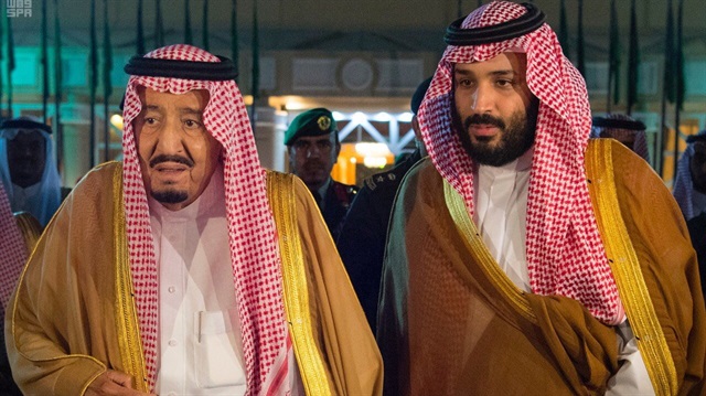 Saudi Arabia's King Salman bin Abdulaziz Al Saud walks with his son and Crown Prince Mohammed bin Salman.