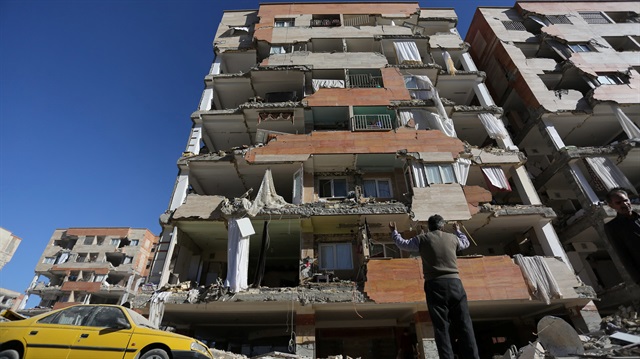 A man reacts as he looks at a damaged building following an earth quake in Sarpol-e Zahab county in Kermanshah, Iran.
