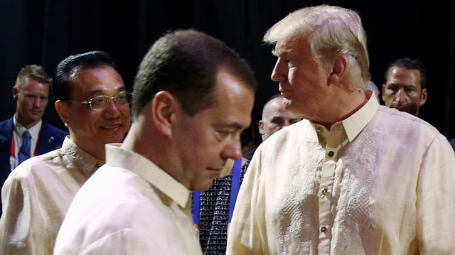 Russia's Prime Minister Dmitry Medvedev (L) crosses paths with China's Premier Li Keqiang and U.S. President Donald Trump at the Association of Southeast Asian Nations (ASEAN) Summit gala dinner in Manila, Philippines.