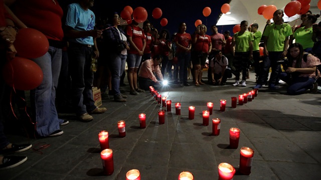 File Photo-Members of Mexico's HIV/AIDS social organizations light candles during a vigil to remember those killed by HIV/AIDS and deliver prevention measures to citizens