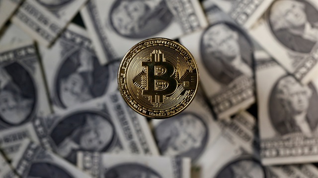A bitcoin (virtual currency) coin placed on Dollar banknotes
