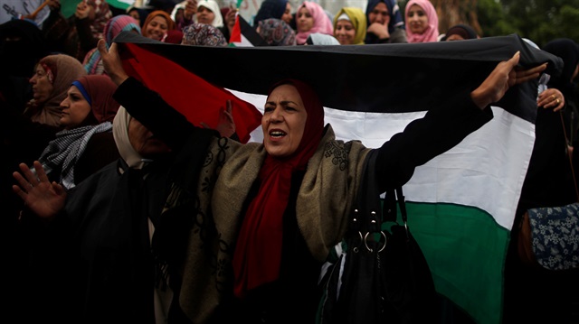 A woman holds a Palestinian flag during a protest against the U.S. intention to move its embassy to Jerusalem and to recognize the city of Jerusalem as the capital of Israel, in Gaza City December 6, 2017.