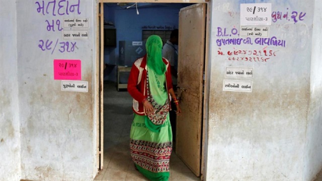 A woman leaves a polling booth after casting her vote during the first phase of Gujarat state assembly election in Panshina village of Surendranagar district